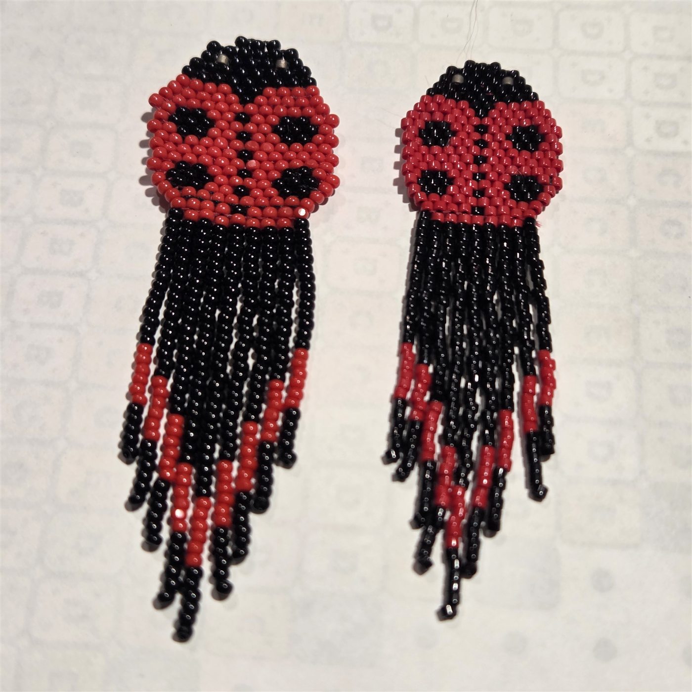 Red and black handmade beaded ladybug fringe earrings