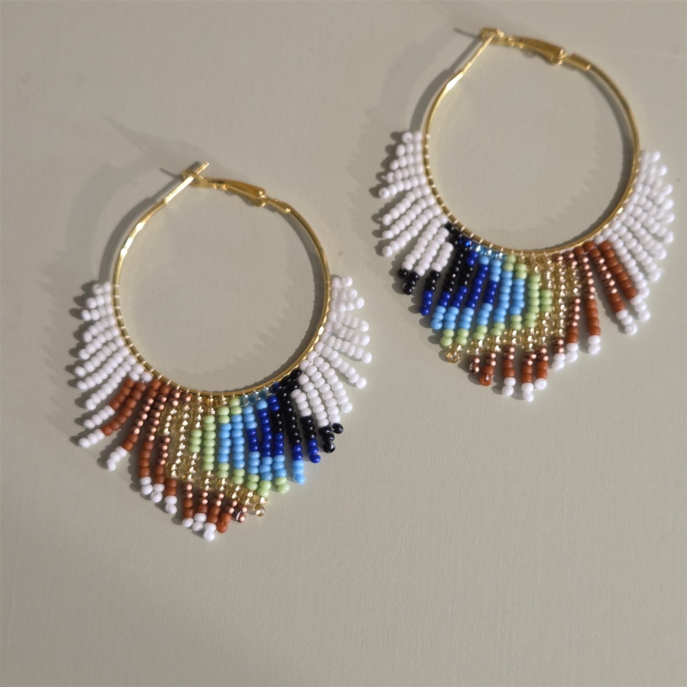 Gold hoop earrings with white and rainbow handmade beadwork